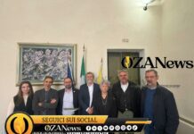 Salento-Libano, un ponte con il caseificio Group of people posing for a photo in front of flags and artwork. News event.