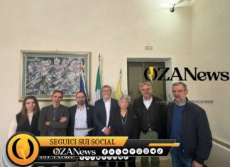 Salento-Libano, un ponte con il caseificio Group of people posing for a photo in front of flags and artwork. News event.