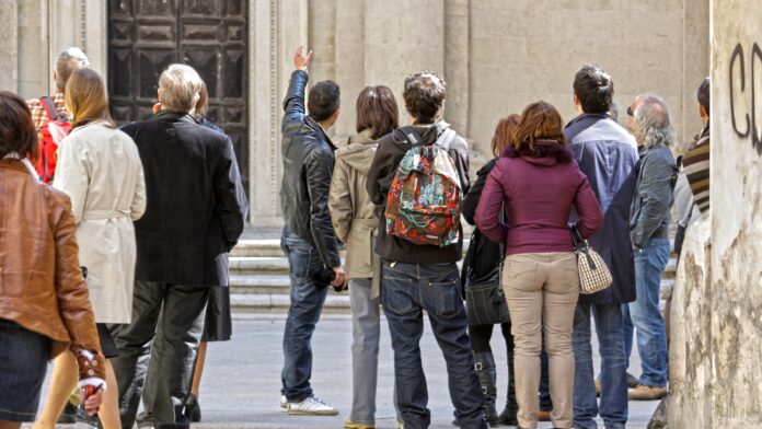 Gruppo di turisti con guida davanti a monumento