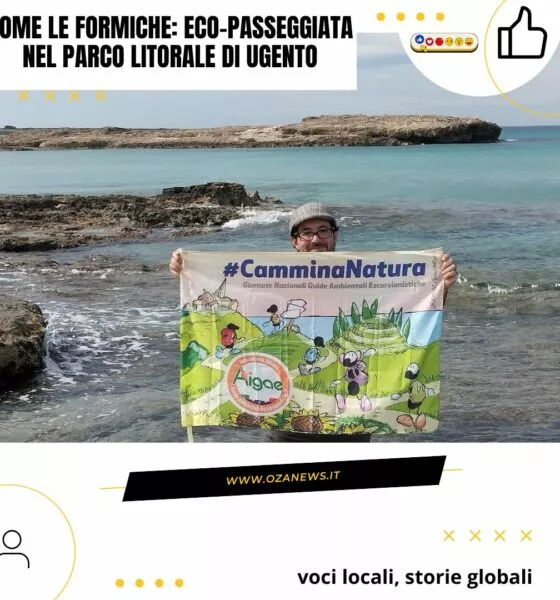 Eco-Passeggiata nel Parco Litorale di Ugento. Man holding #CamminaNatura banner by the sea. Tourism in Ugento.